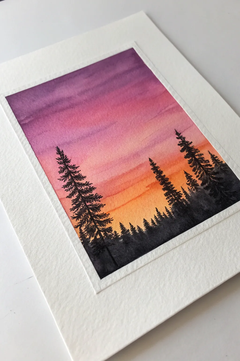 Simple sunset gradient and bold pine silhouettes, a clean postcard-style painting idea
