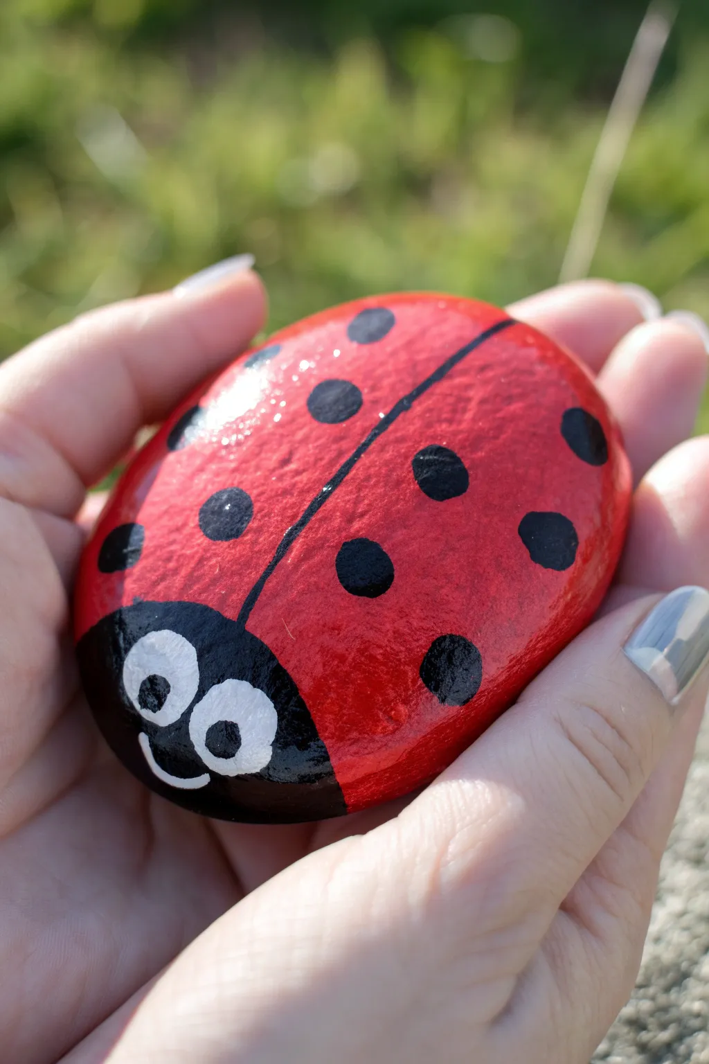 Simple ladybug dot rocks: bold red, crisp black spots, and a cozy garden backdrop.