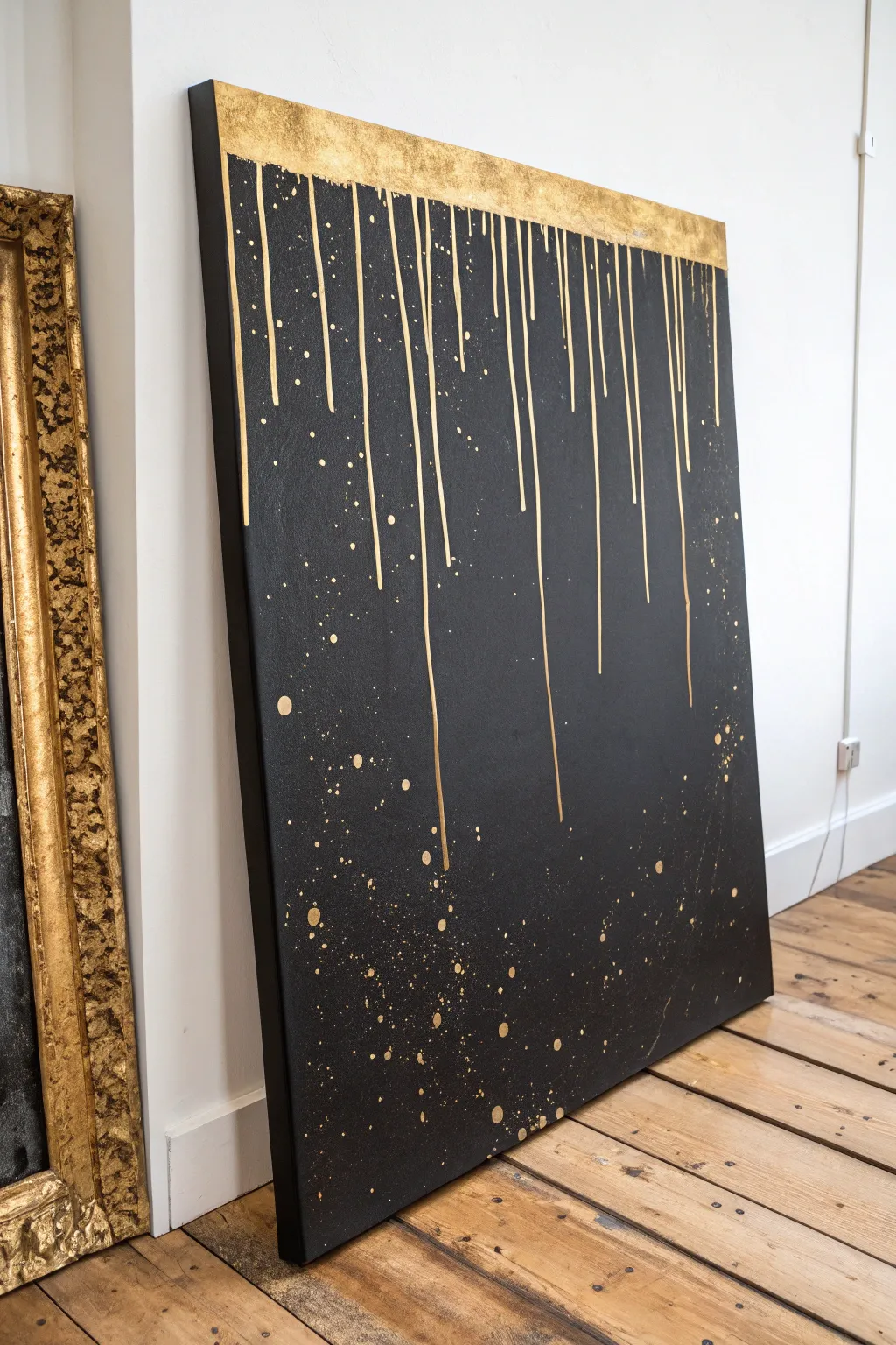 Matte black canvas with bold metallic gold drips for a chic minimalist-boho statement