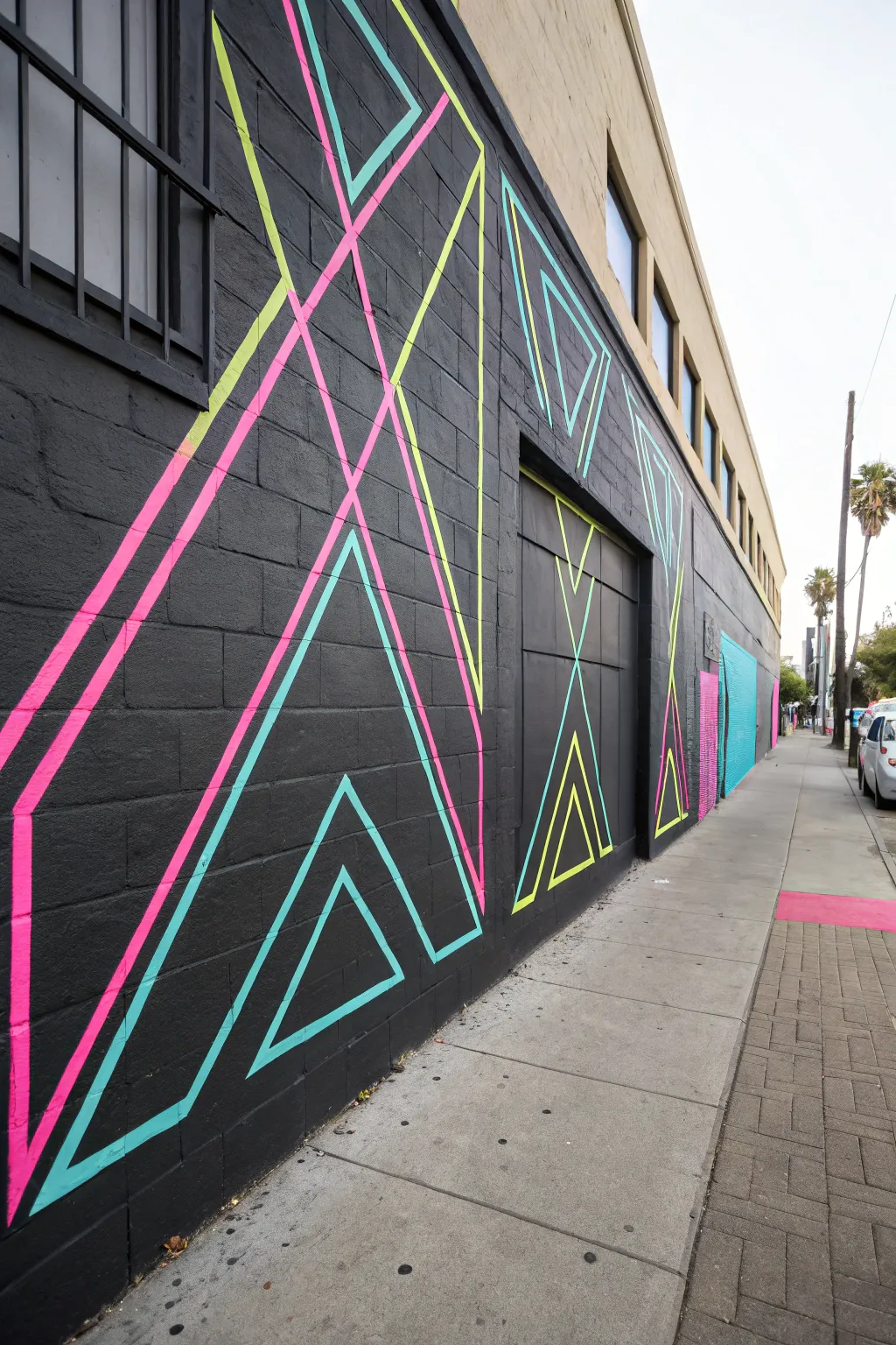 Crisp UV neon triangles and lines on matte black for a bold, minimalist blacklight wall.