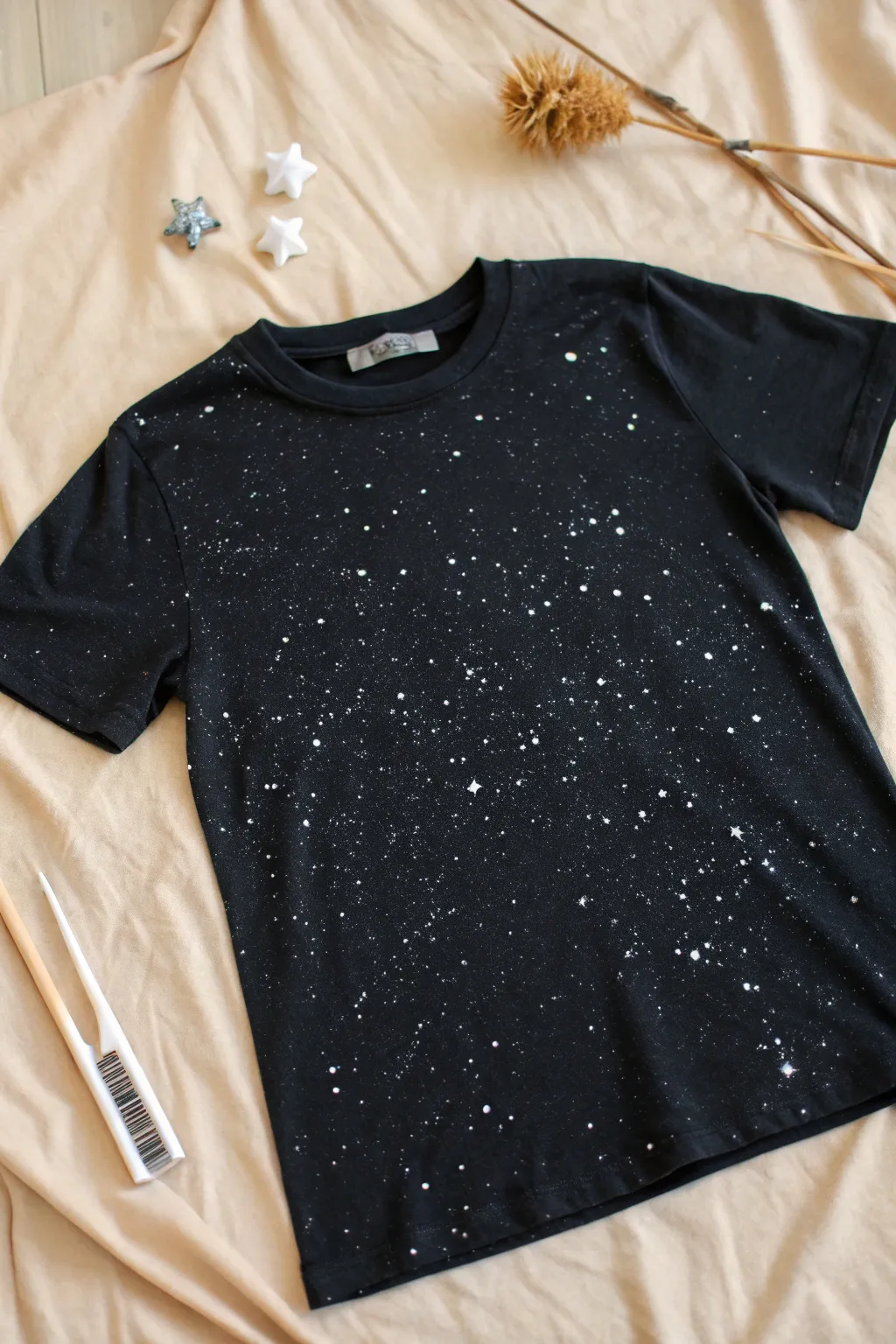 Classic bleach splatter galaxy tee, clean minimal flat lay with a subtle work in progress touch