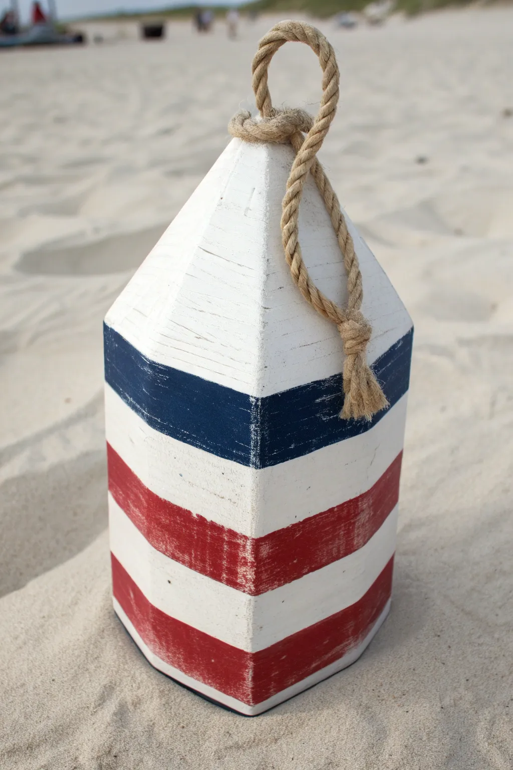 Classic coastal stripes on a hand-painted spindle buoy for clean, nautical charm at home.