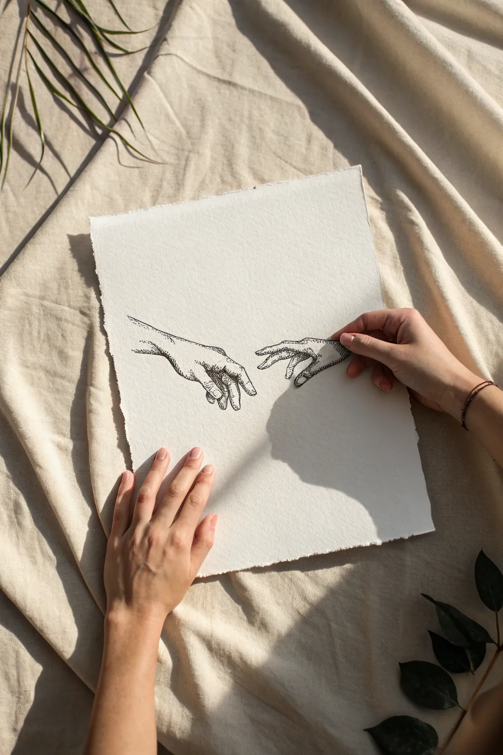 Two hands nearly touching on textured paper, a minimalist moment of connection and tension.