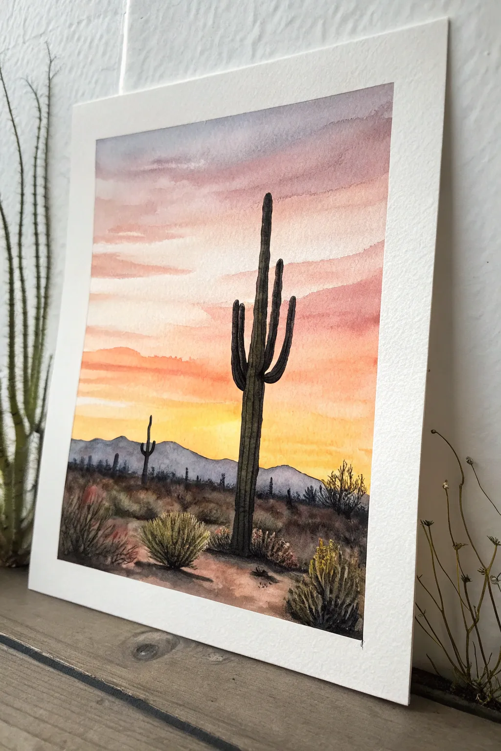 Classic saguaro silhouette set against a dreamy pink-to-gold sunset gradient, clean and bold.