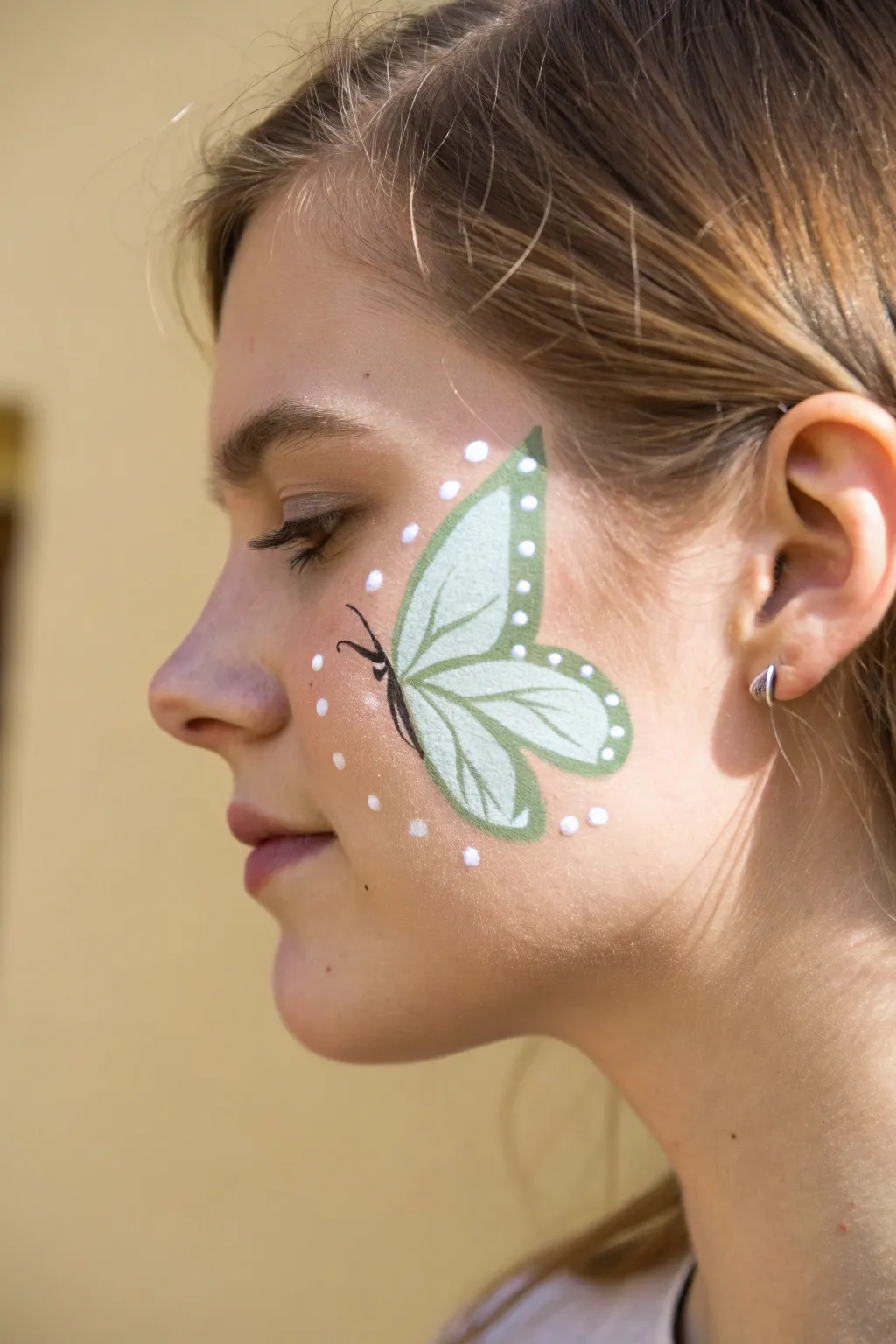 Minimal butterfly wing cheek paint with clean outline and dotted highlights, perfect for beginners
