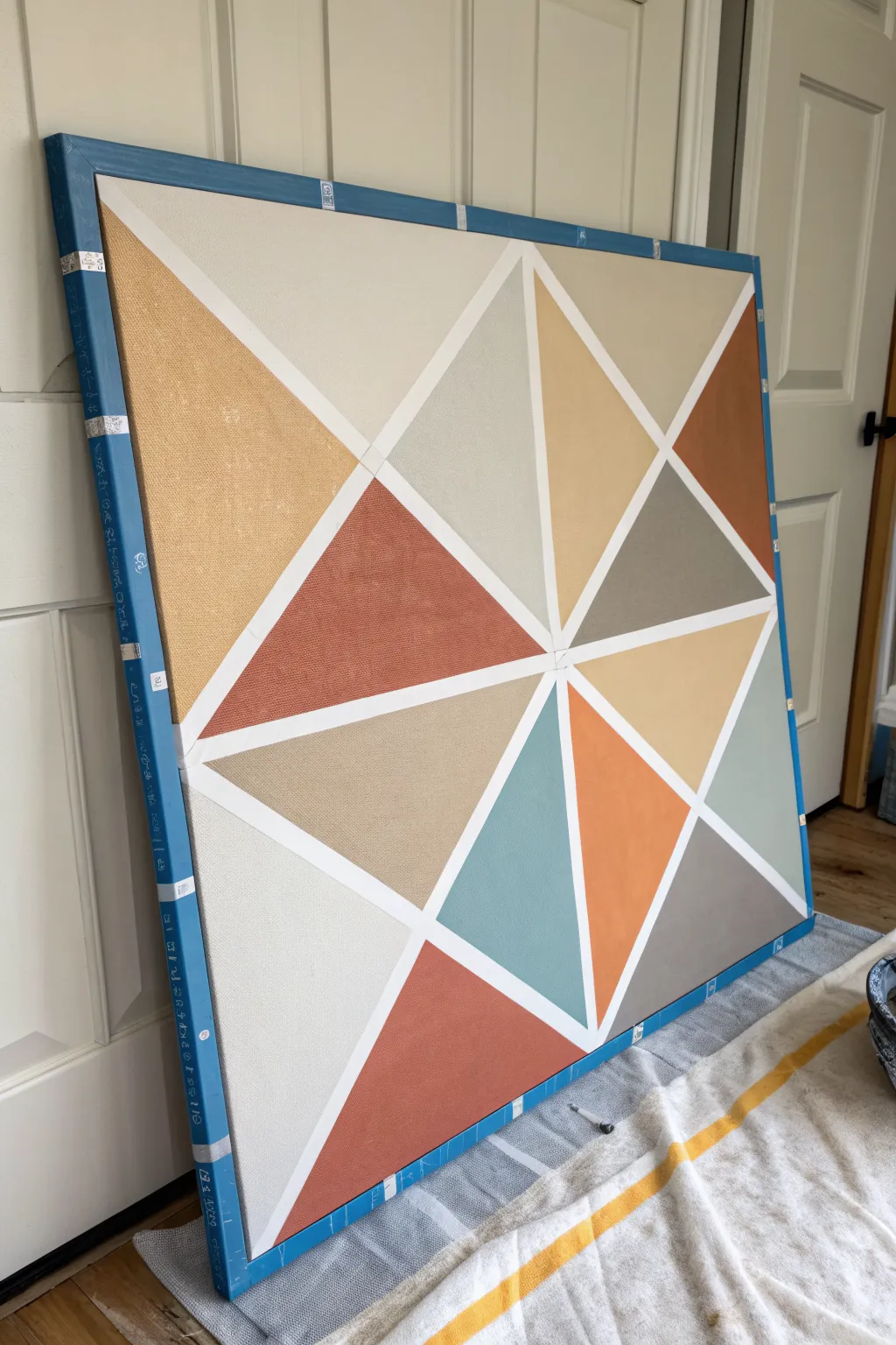 Modern tape-resist color blocks in soft neutrals with one bold accent, mid-project charm