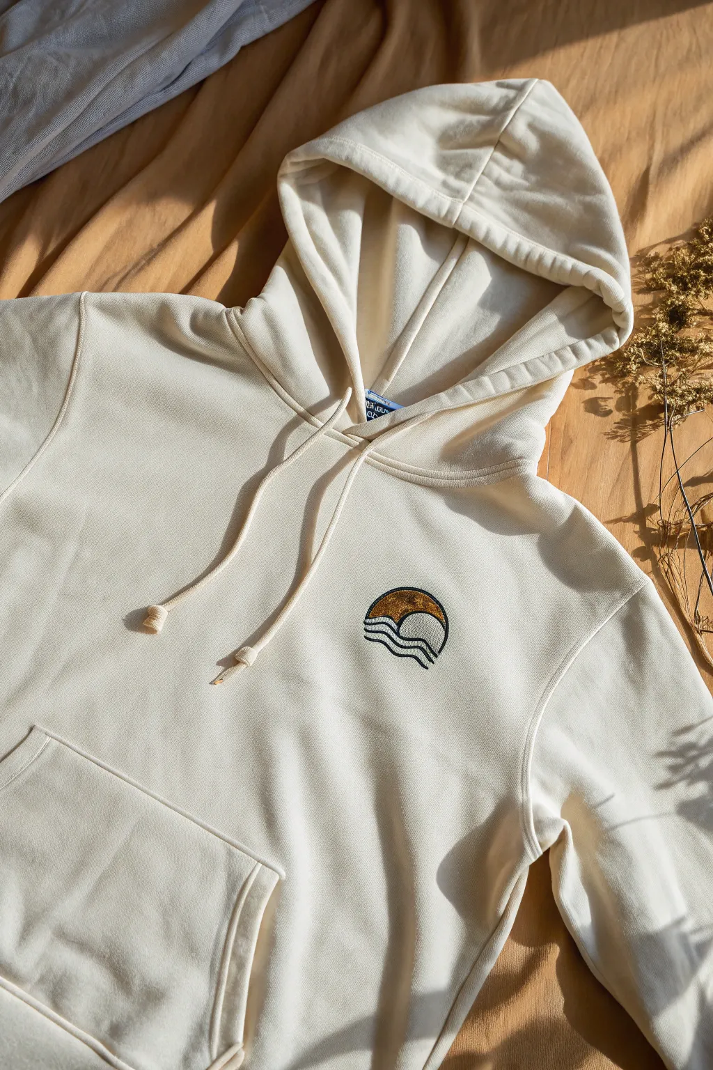 Minimal center-chest icon on a clean hoodie flat-lay, simple two-tone paint for modern calm