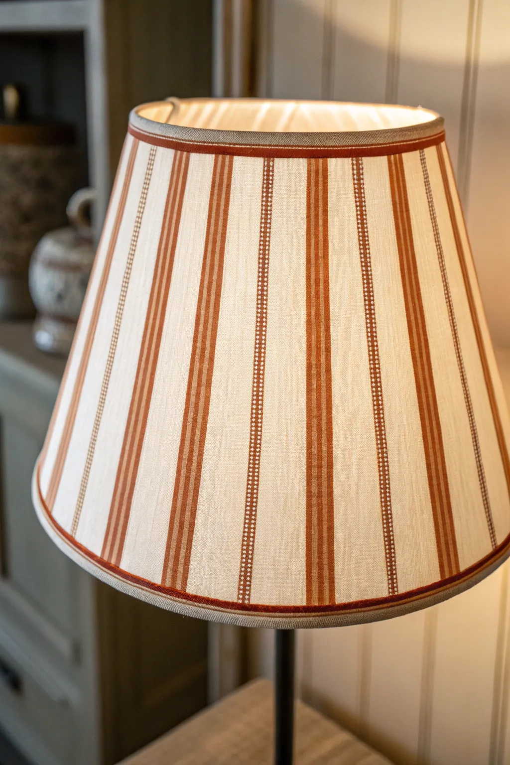 Classic two-color stripes on a tapered lampshade, clean lines and a gentle warm glow.