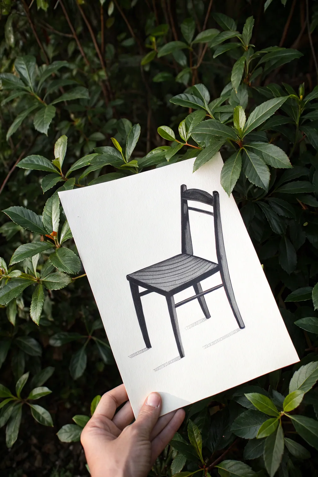 Negative space chair study with bold charcoal fill, letting white paper define the form.