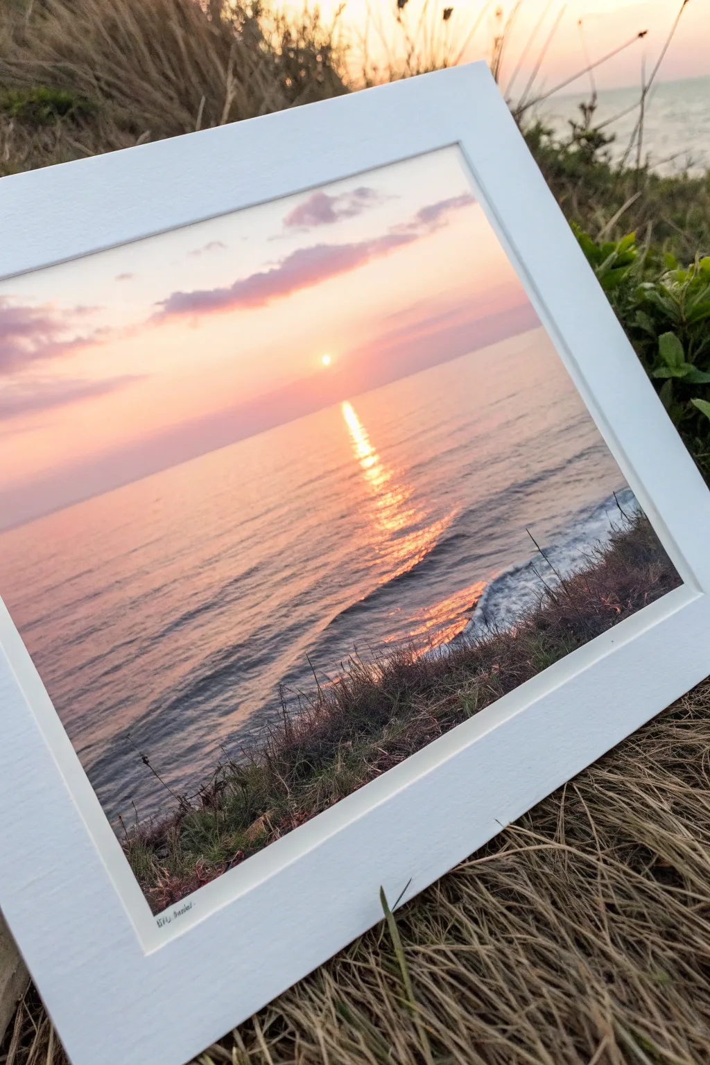 Classic sunset seascape with peach, coral and lavender glow reflected on calm water