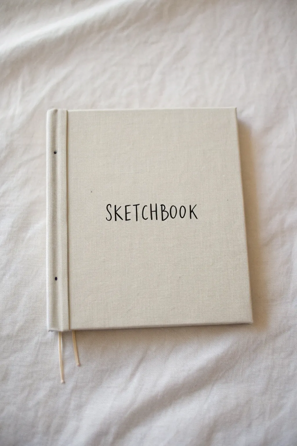 Bold hand-lettered sketchbook cover with simple ink flourishes and faint pencil guidelines.