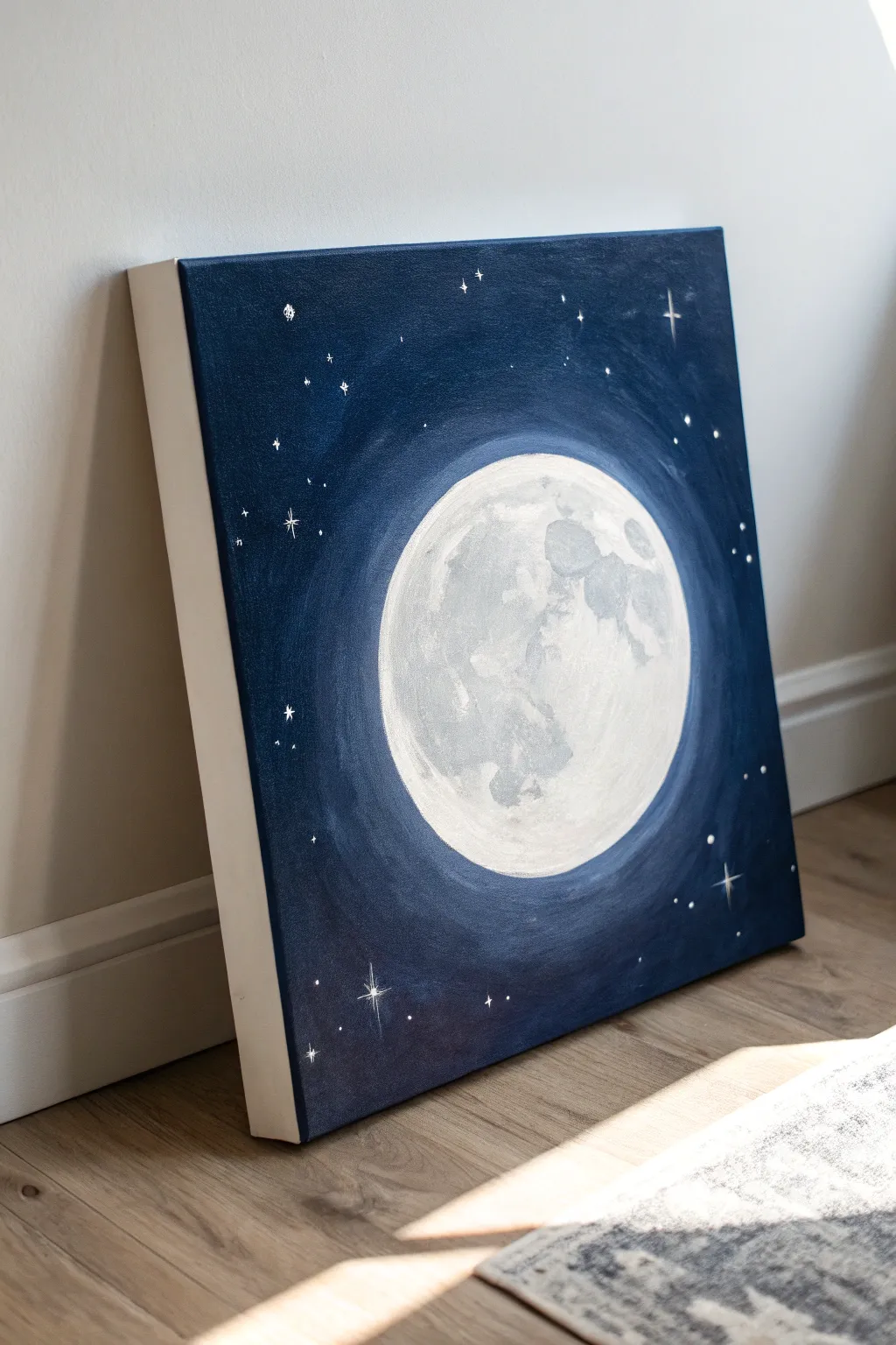 Glowing full moon painting on white canvas, dark sky contrast with soft halo and tiny stars
