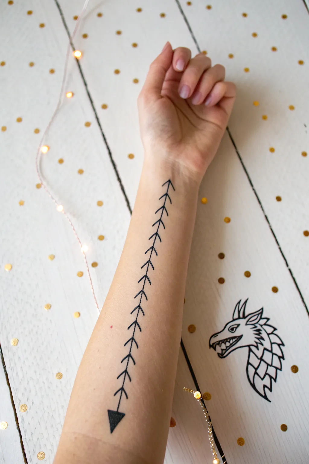 Mini dragon spine arm paint: wavy line, triangle spikes, tiny head and sparkle dots