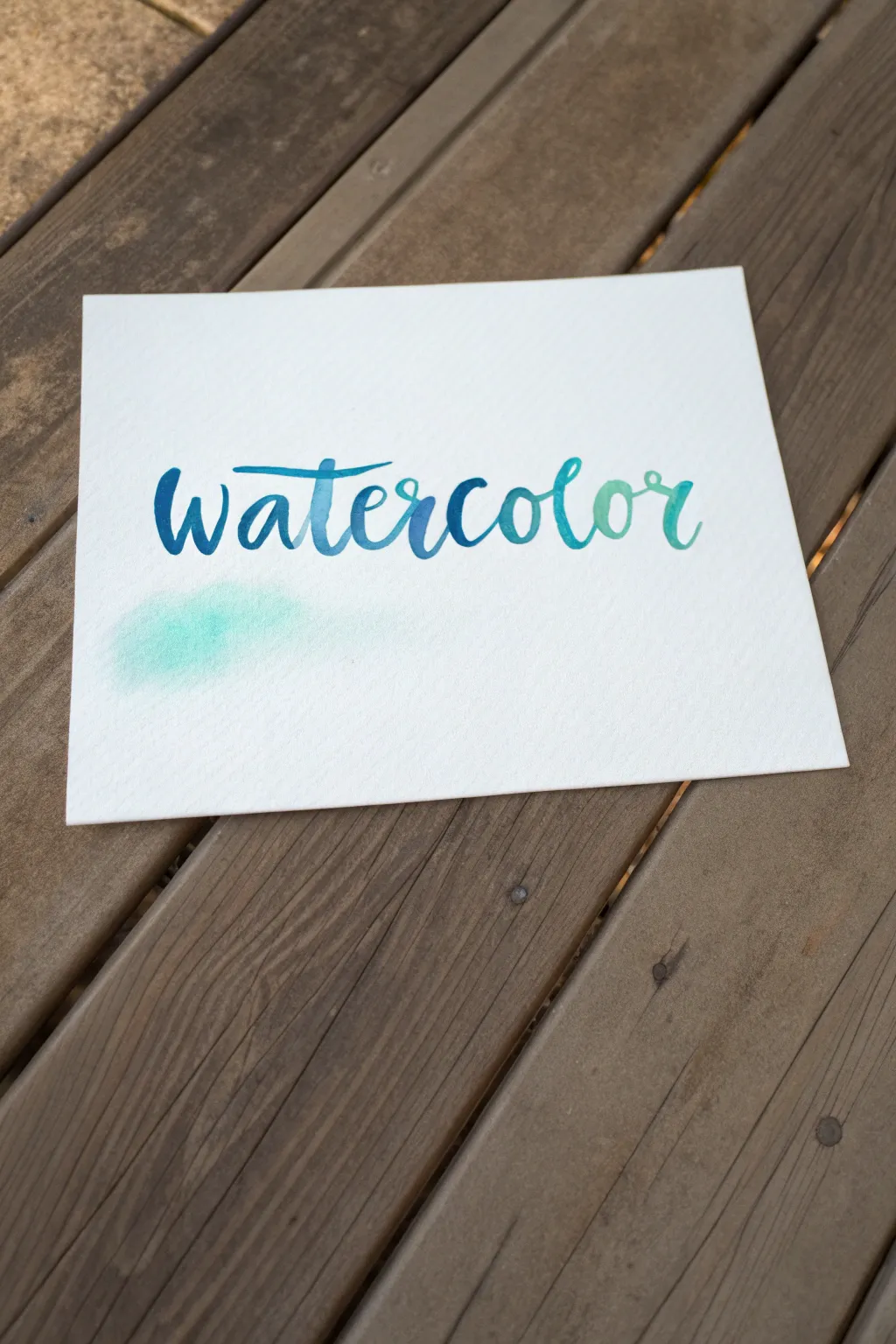 Close-up watercolor word art with bold brush lettering, soft blooms, and calming blue gradients.