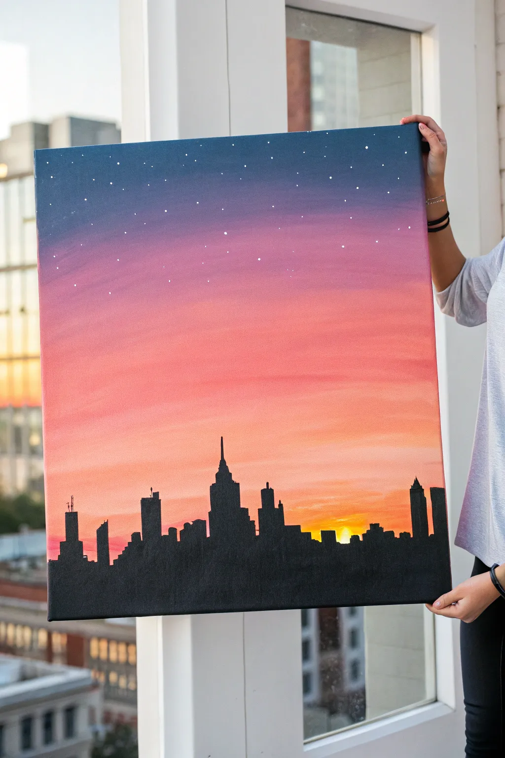 City skyline silhouette at sunset, an easy acrylic idea with bold contrast and cozy window glow