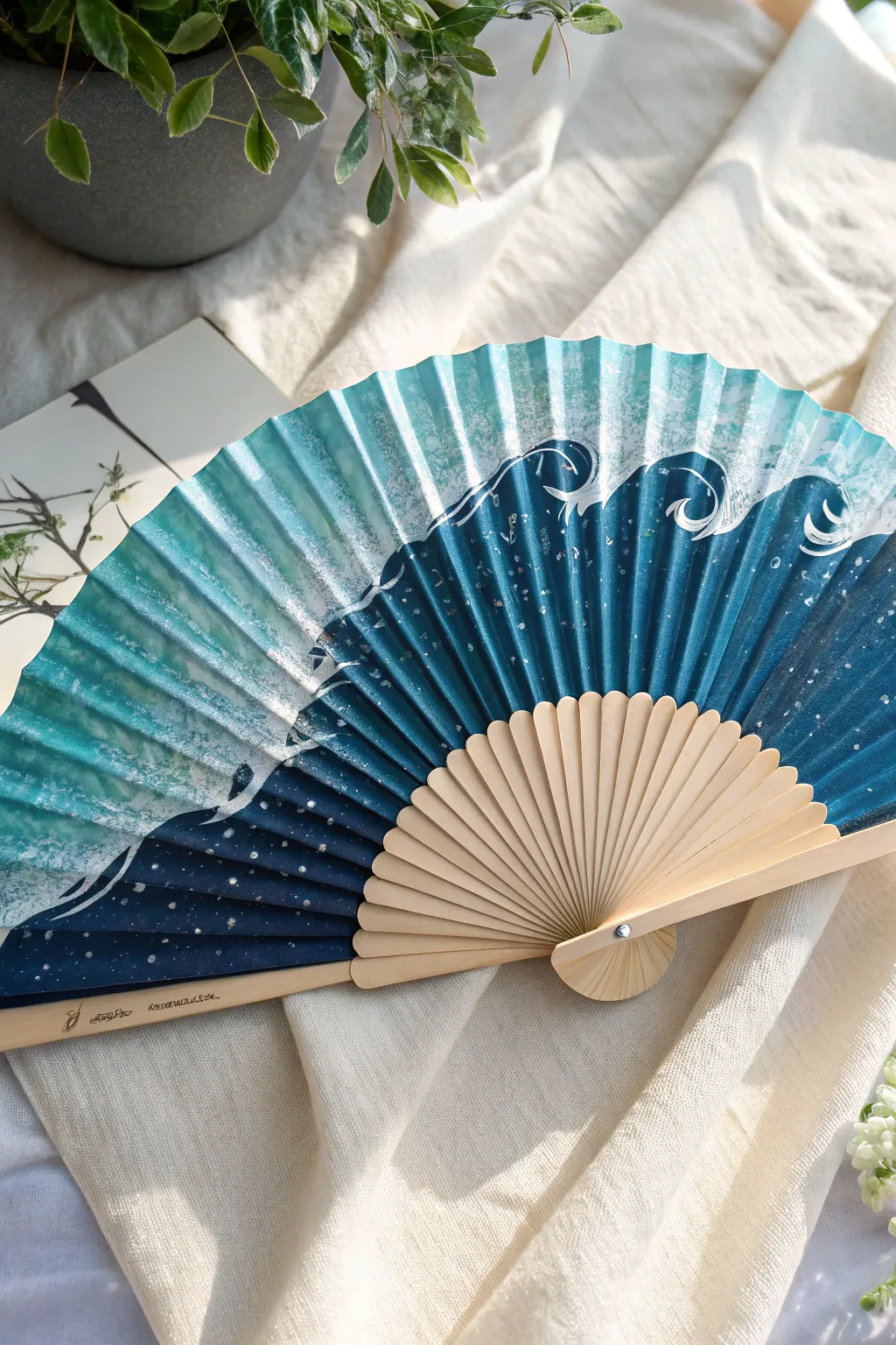 Ocean waves across a folding fan: layered blues, crisp white foam, and calm minimalist styling.