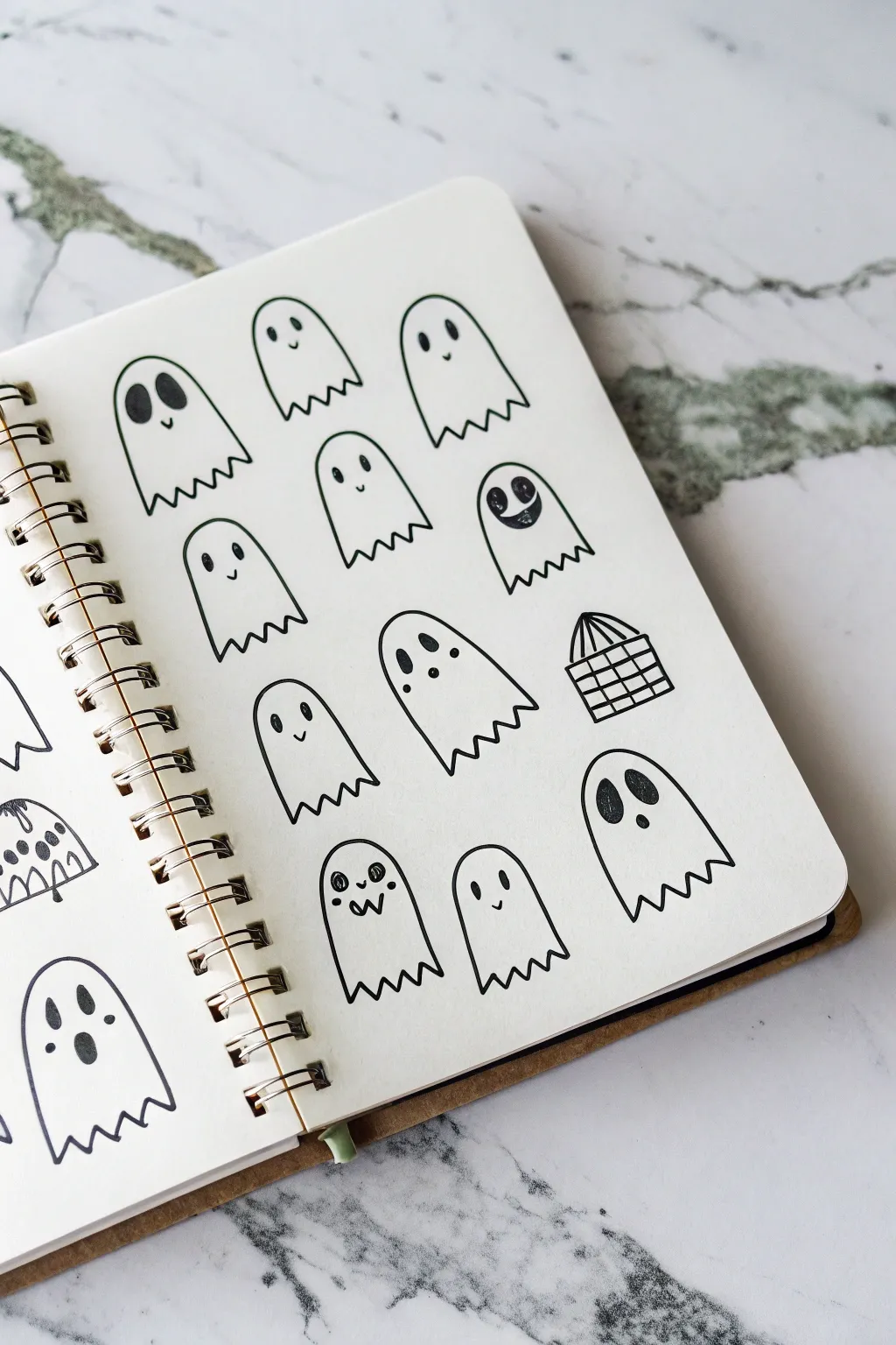 A minimalist ghost doodle sheet: 12 quick variations in bold ink with plenty of white space.
