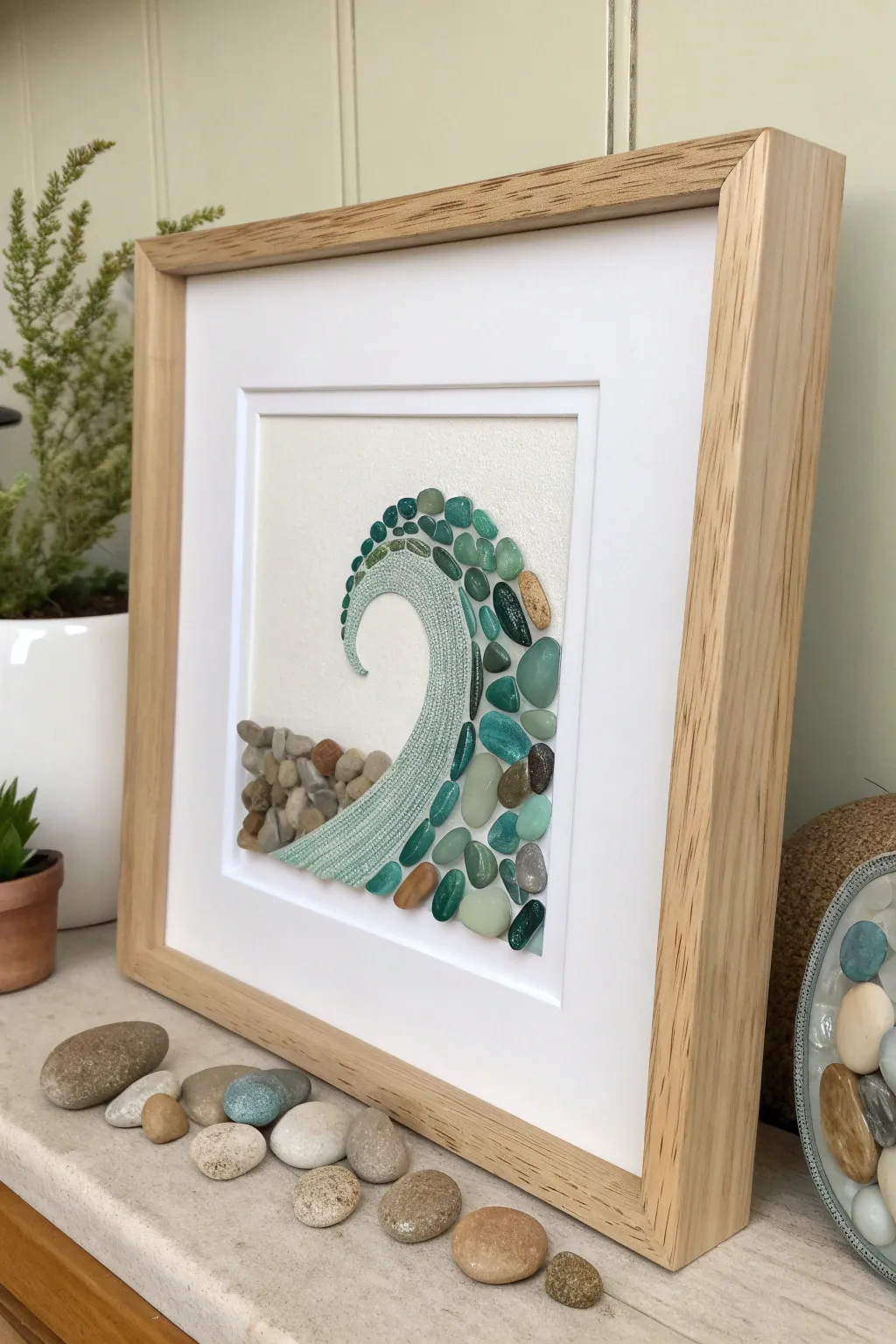 DIY sea glass wave art in a light wood frame, calm coastal palette and minimalist vibe.