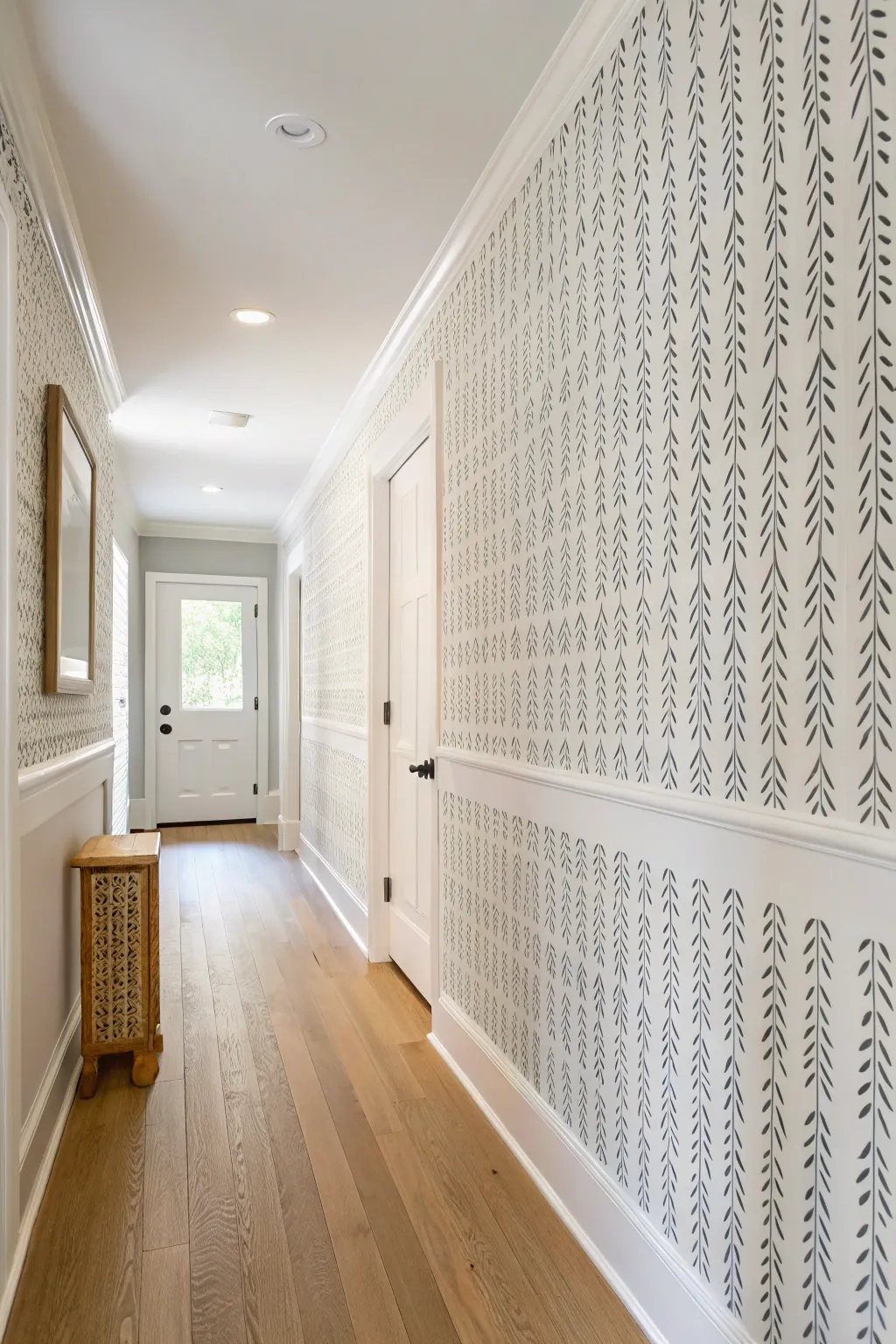 Graphic hand-painted dash wall adds modern rhythm to a calm hallway, with a cozy in-progress touch.