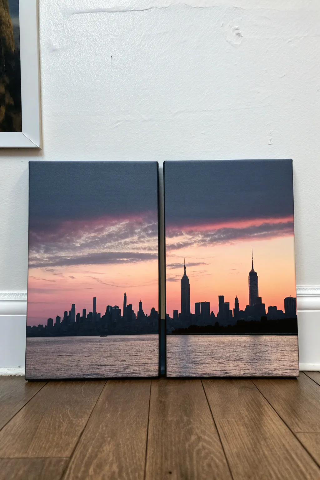 Matched city skylines diptych with shared gradient sky and drifting clouds across the seam