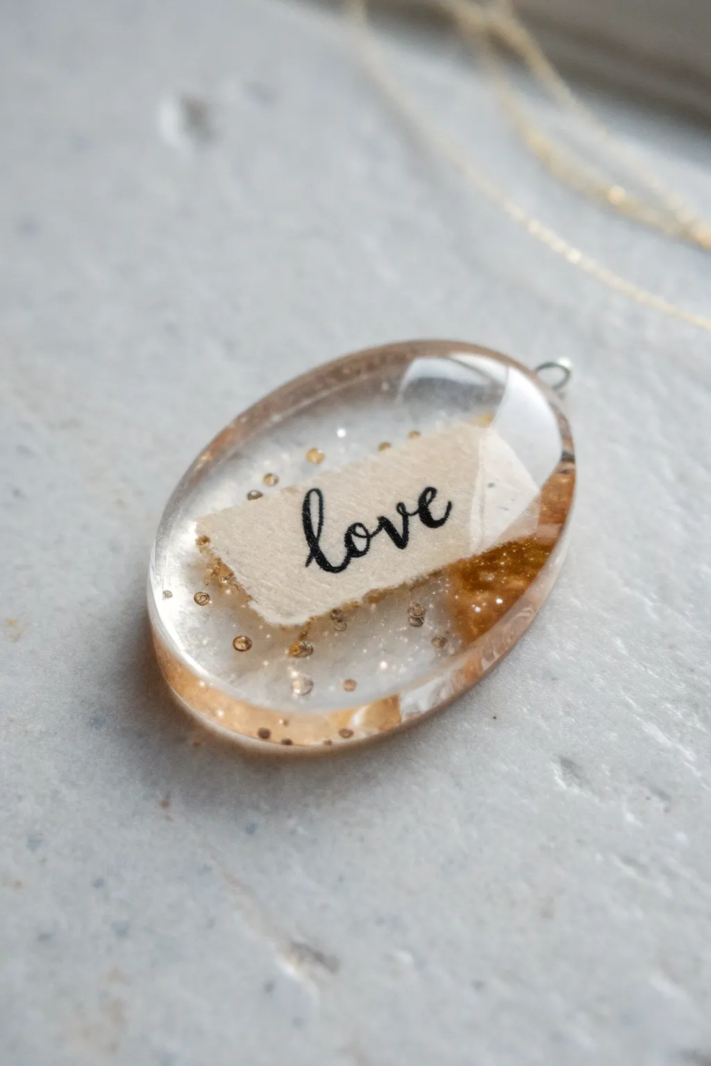 Minimal resin pendant with a single handwritten word insert, modern and sentimental.