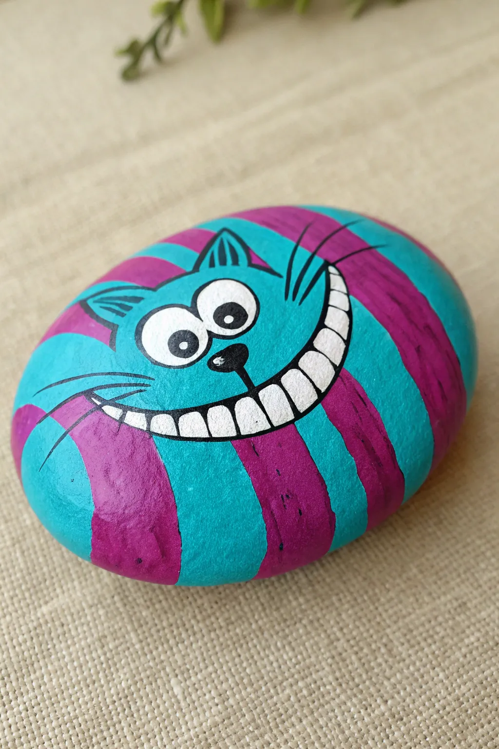 A bold striped rock with a floating grin and eyes for a playful Disney-inspired painting idea