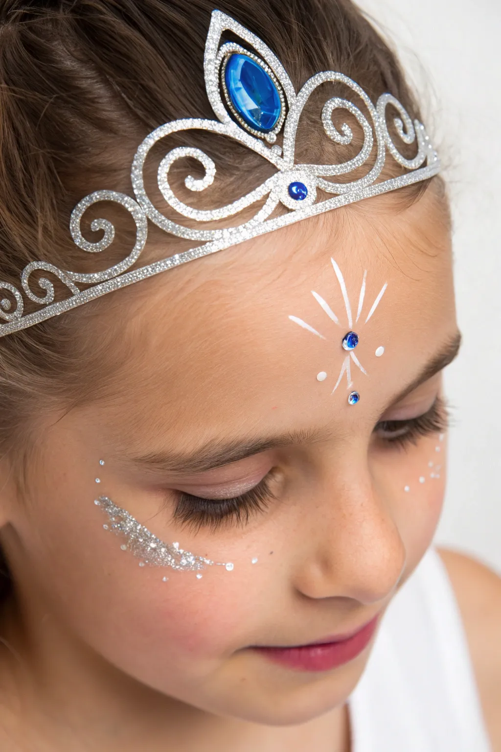 Transform into royalty with this simple yet sparkling glittery tiara face paint design.