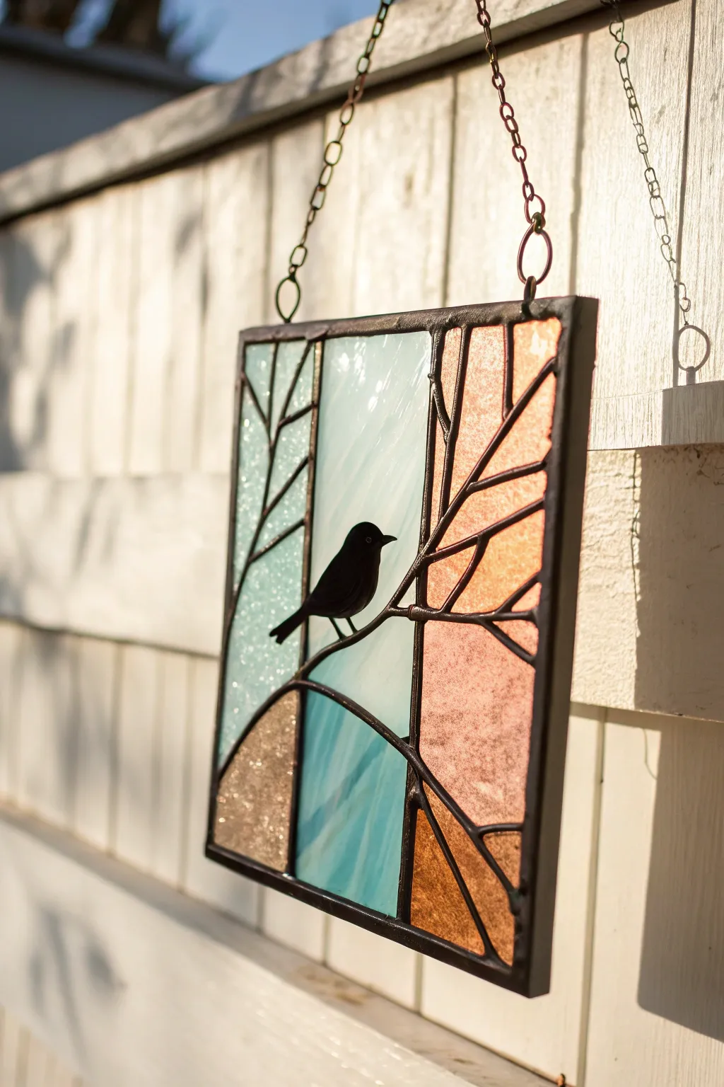 Minimal bird-on-branch stained glass silhouette with bold black lines and soft sky panels.