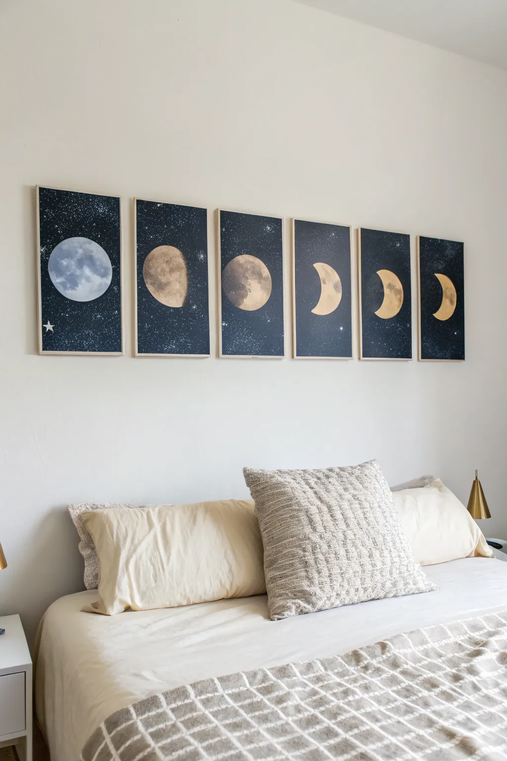 Soft neutral moon-phase canvases above the bed for a cozy, minimalist boho bedroom glow