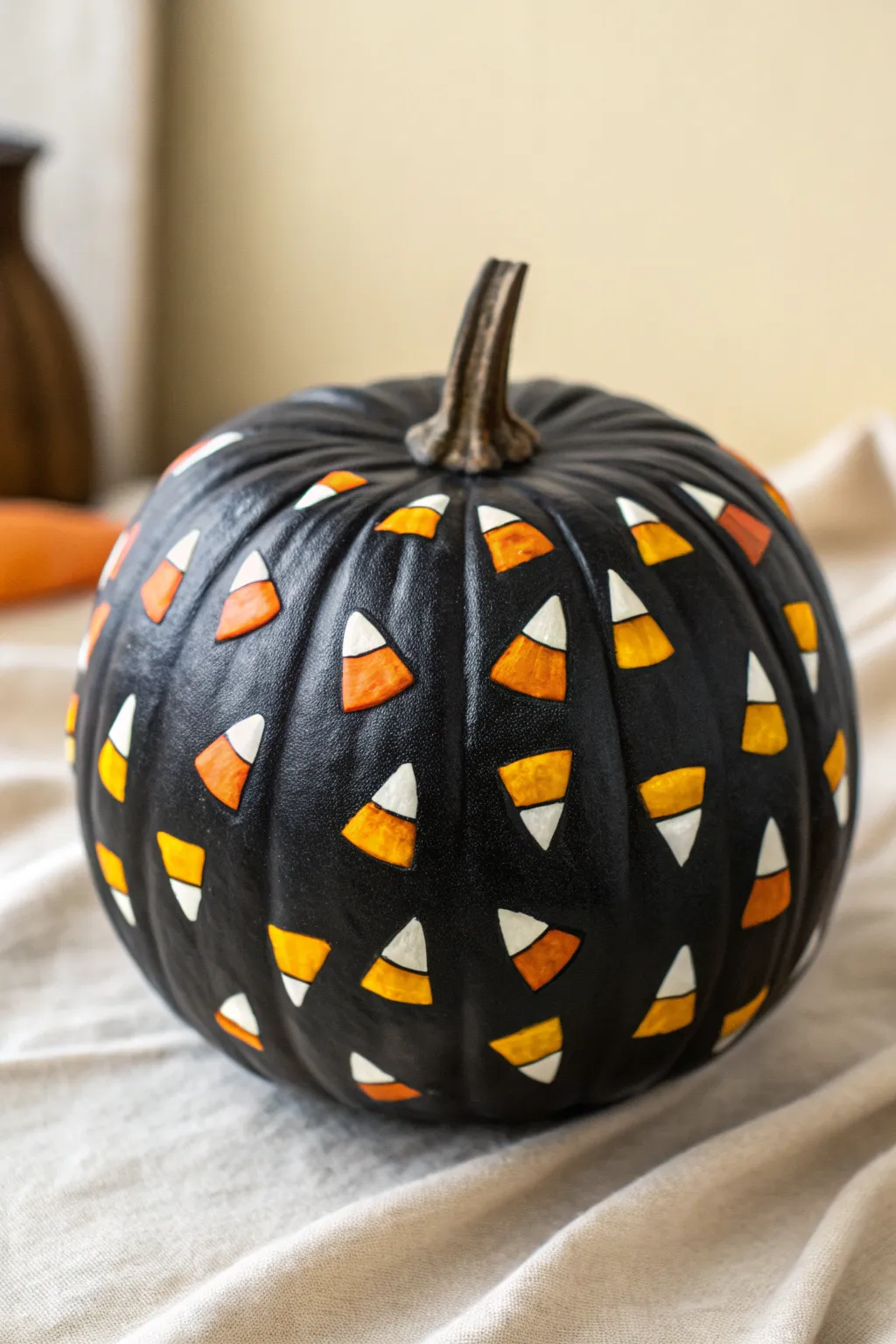 Mini candy corn motifs pop on a matte black pumpkin for chic spooky minimalist Halloween decor.