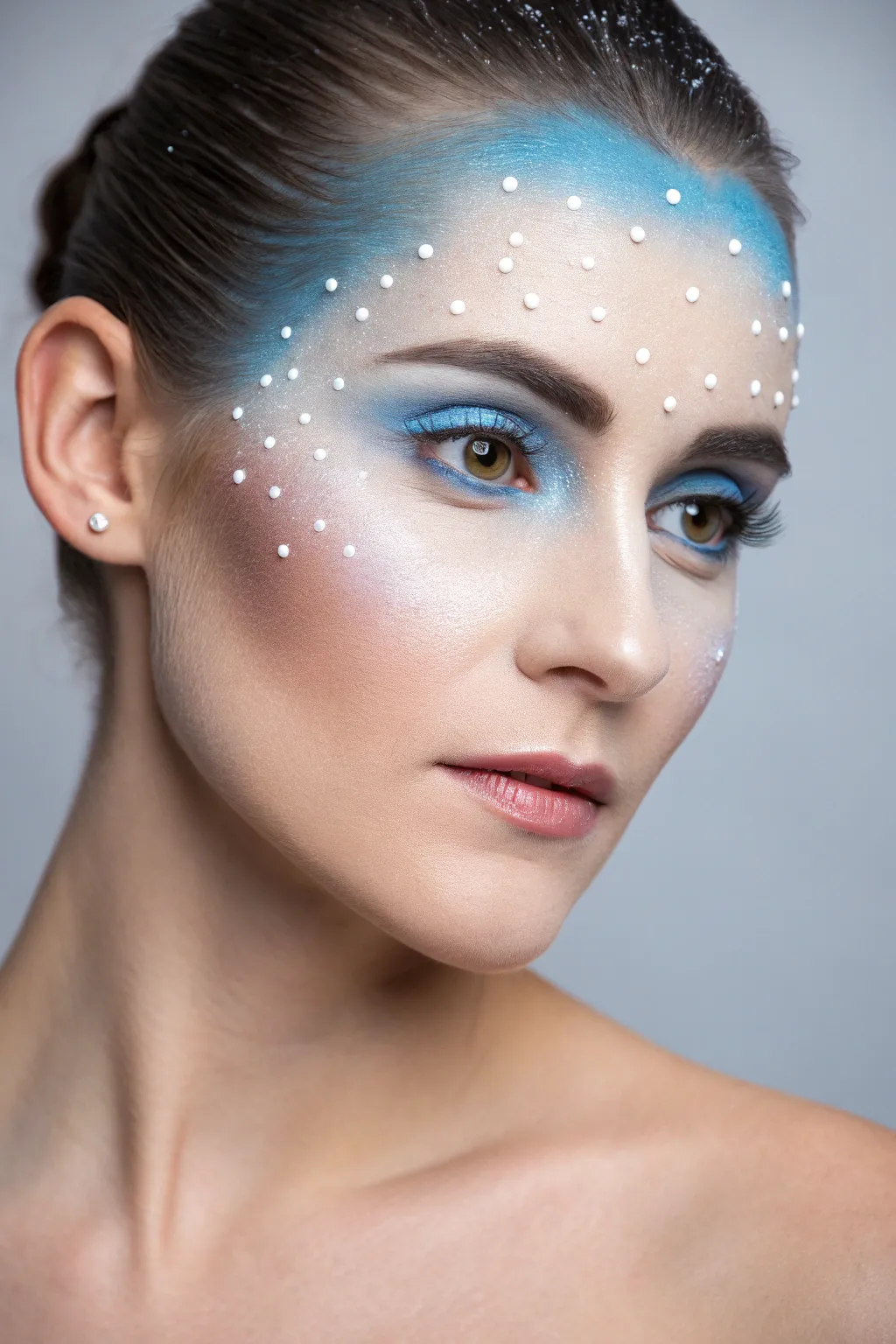 Snowflake temples and icy gradients create a frosty blue-white winter glow face paint look