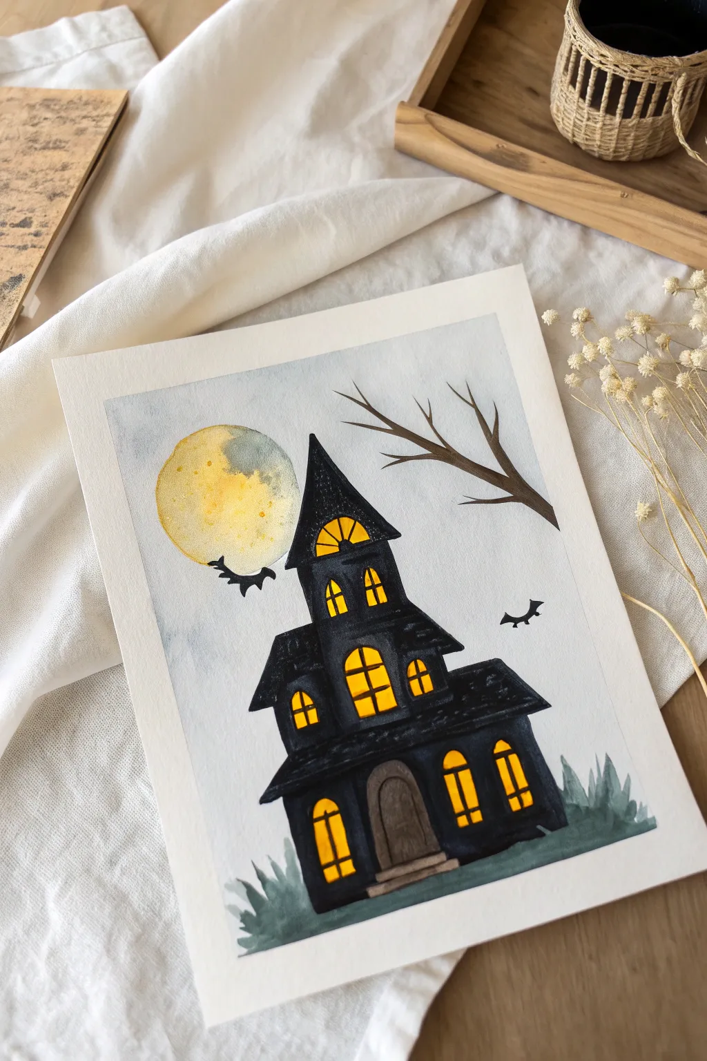 Simple haunted house silhouette with glowing yellow windows, a fun Halloween painting idea for kids