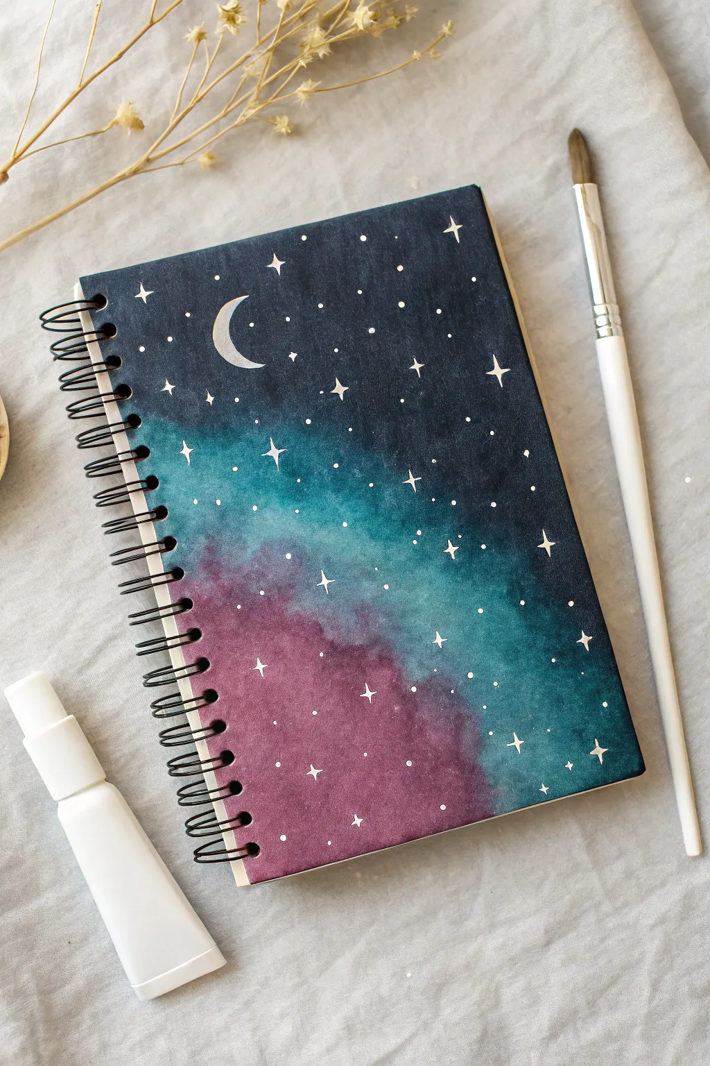 Moody galaxy notebook cover with splattered stars, nebula glow, and a tiny crescent moon