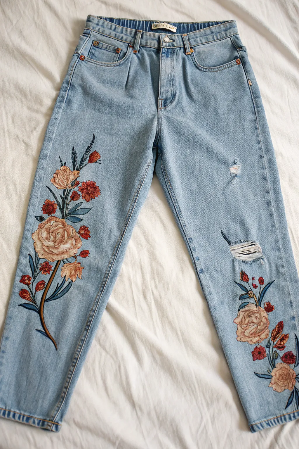 Bold florals painted around frayed rips make distressed jeans look intentional, artsy, and chic.