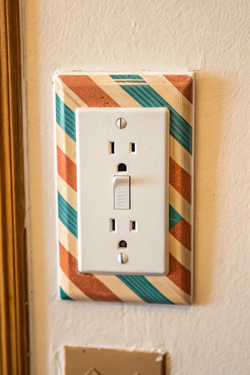 Crisp taped stripes turn a plain outlet cover into bold, minimalist wall detail in minutes.