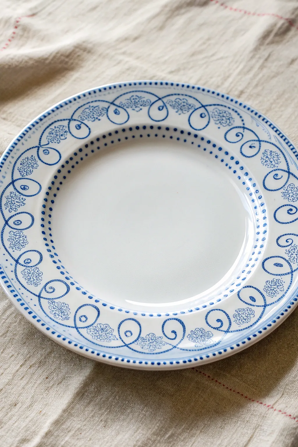 Blue-and-white fine-line scrollwork turns a simple plate into a crisp, artisan centerpiece.