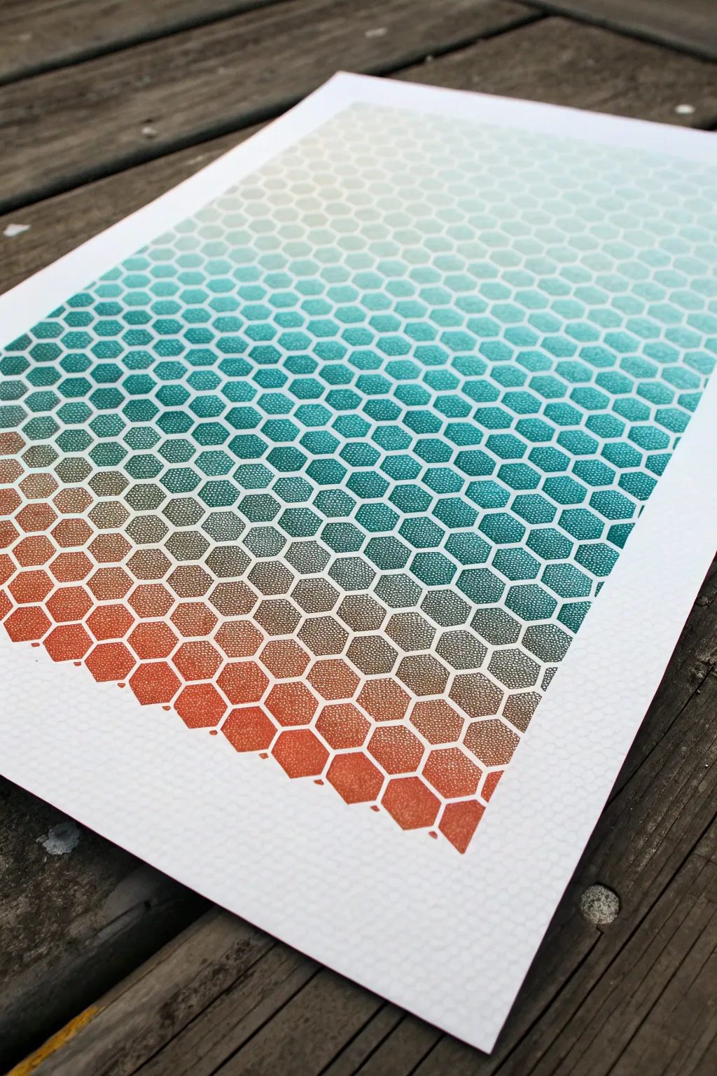 Honeycomb stencil fade: bold teal to terracotta spray gradient on clean minimalist paper
