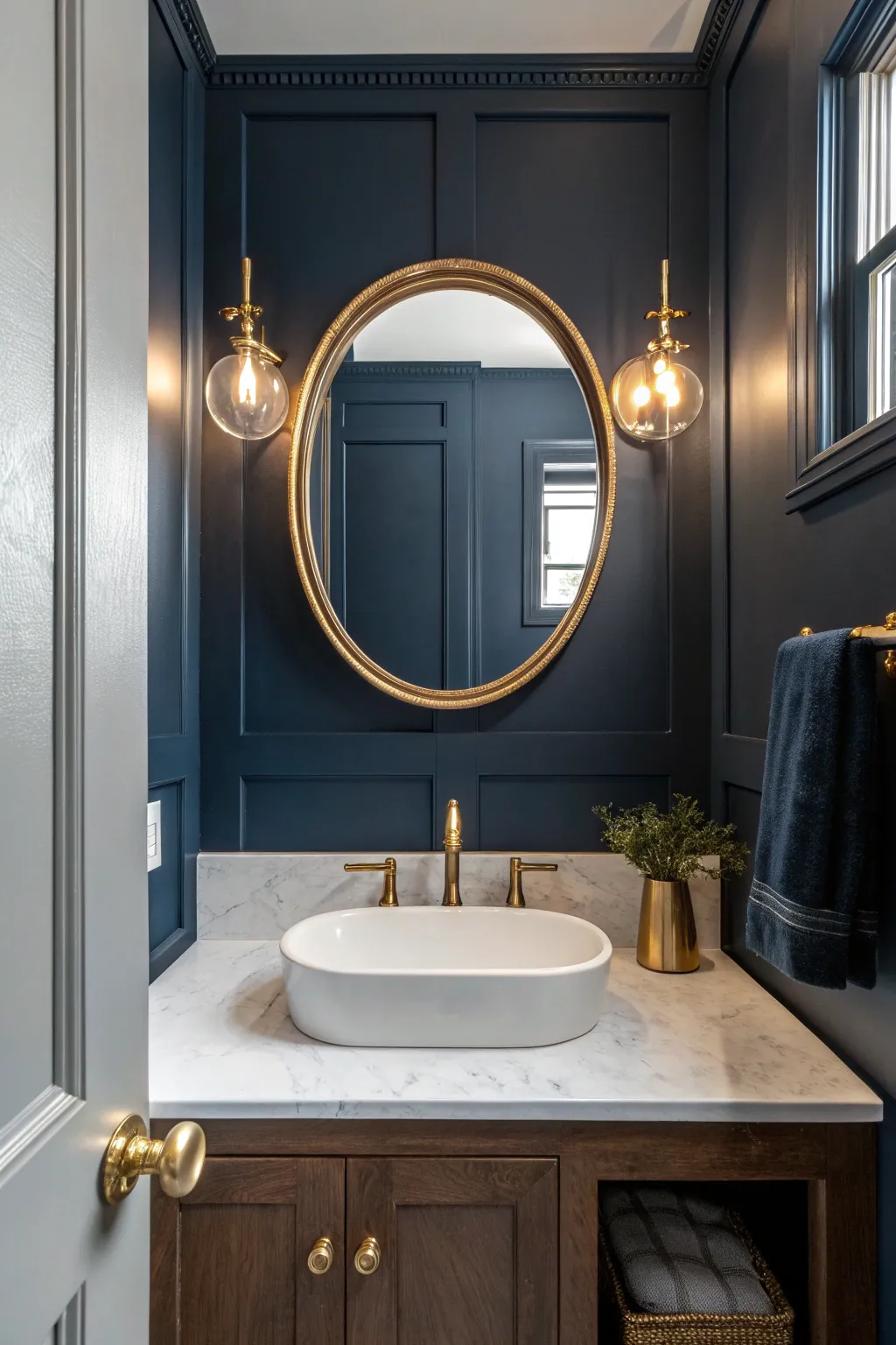 Moody navy walls + a brass round mirror create a jewel-box powder room with dramatic contrast.