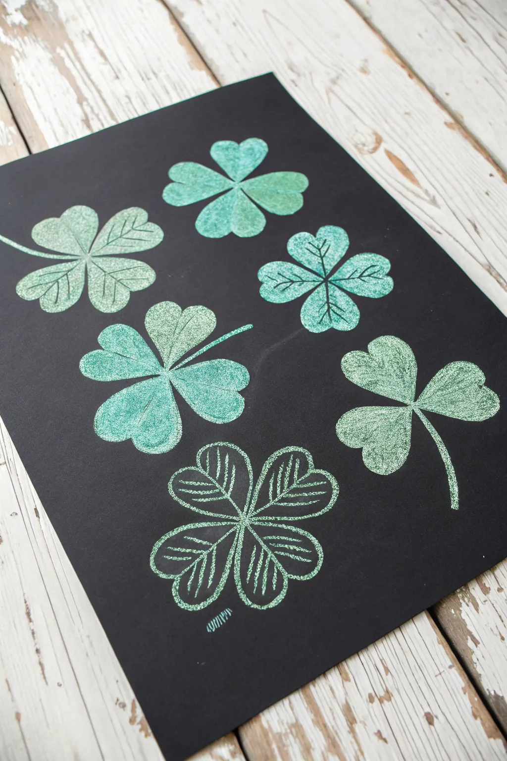 Luminous pastel shamrocks on matte black for a chic modern St Patricks Day painting idea