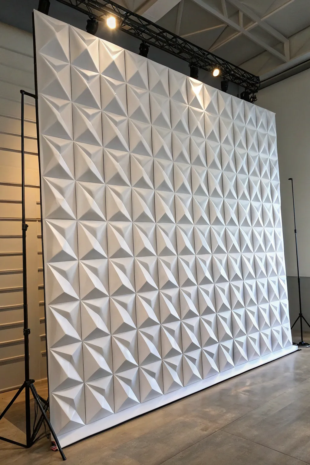Sculptural 3D geometric tile backdrop with crisp side light for bold, modern stage depth