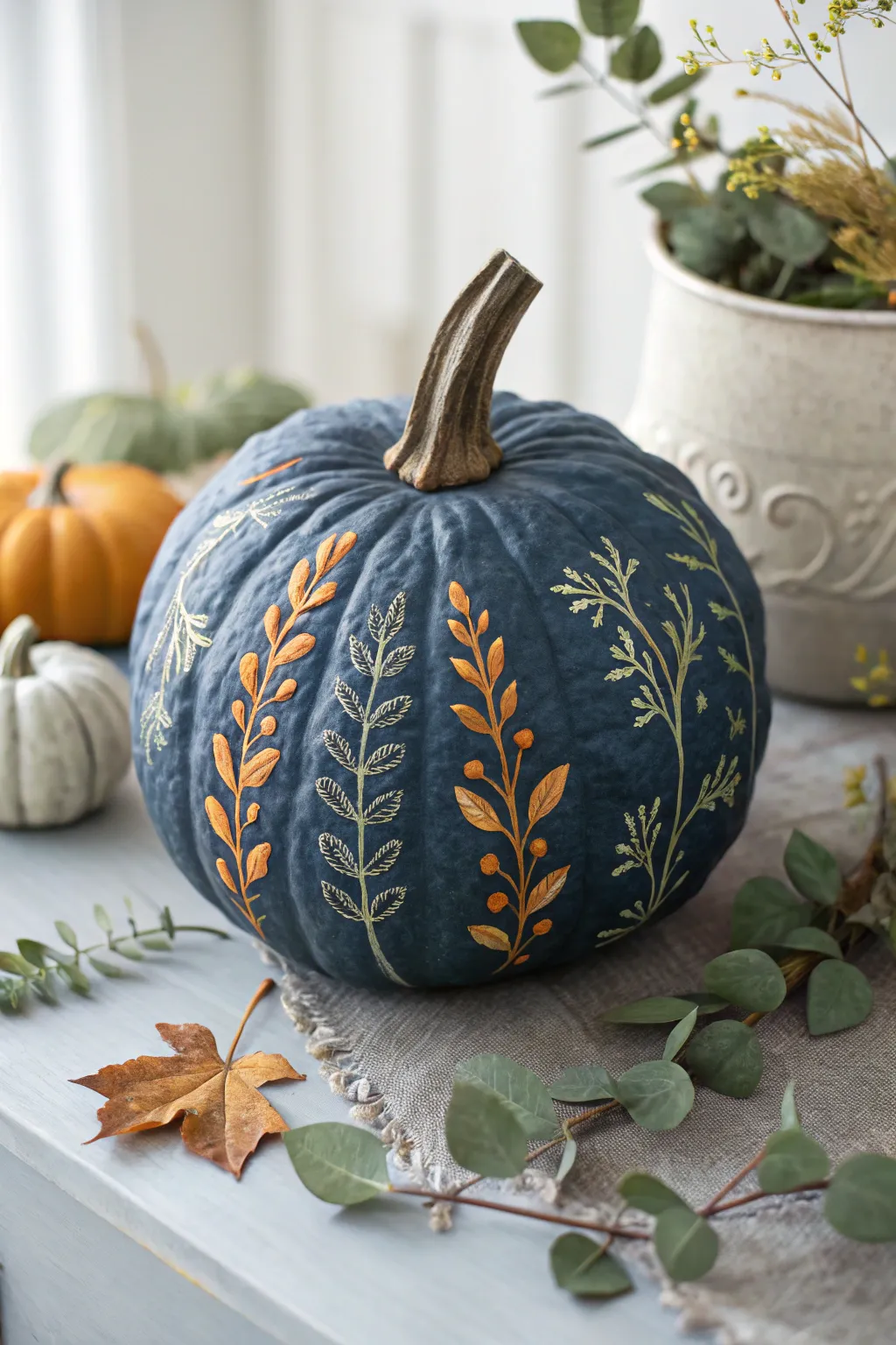 Botanical vines curling through warty bumps on a bold, minimalist painted pumpkin centerpiece.