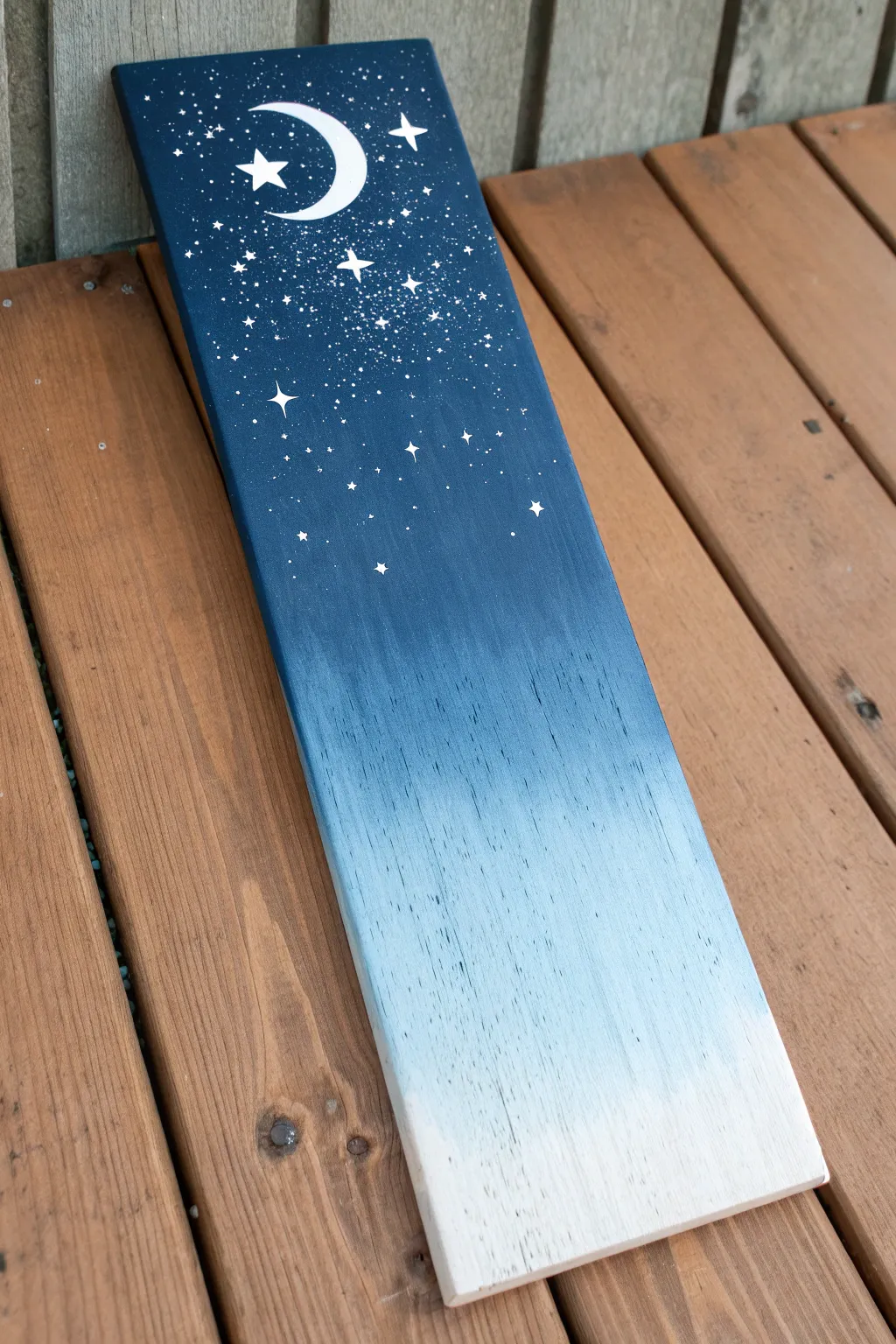 Ombre night sky on wood with splatter stars and a simple moon, grainy texture in focus