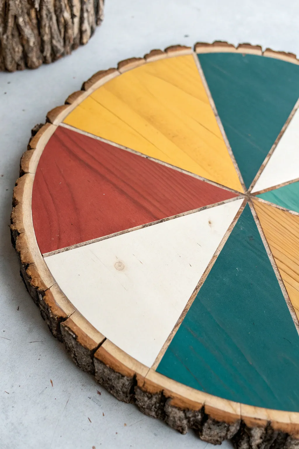 Bold geometric color blocks on a natural wood round, crisp edges and modern boho contrast.
