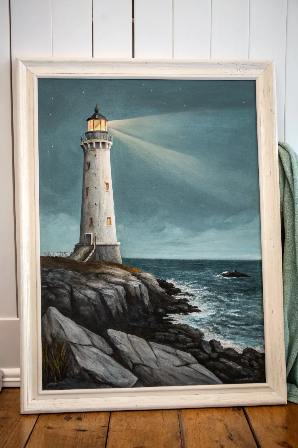 Moody lighthouse acrylic with a soft light beam—minimal waves, bold rocks, Scandinavian calm.