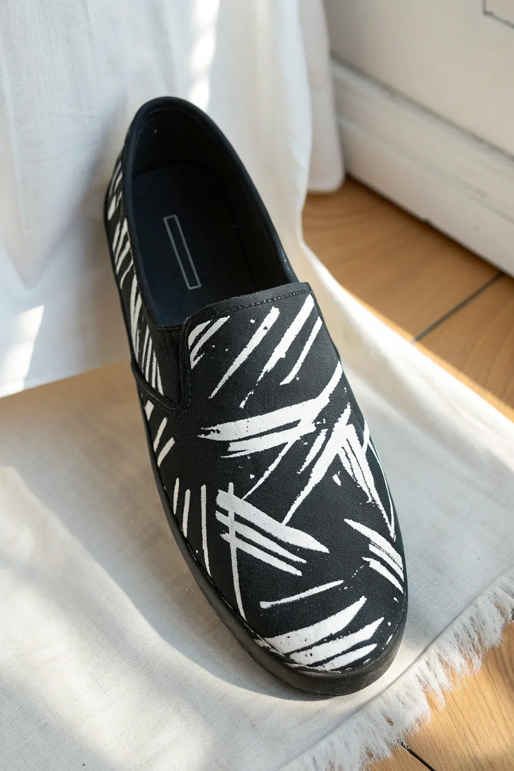 Minimal black shoe with bold white calligraphy brushstrokes, crisp and handcrafted.