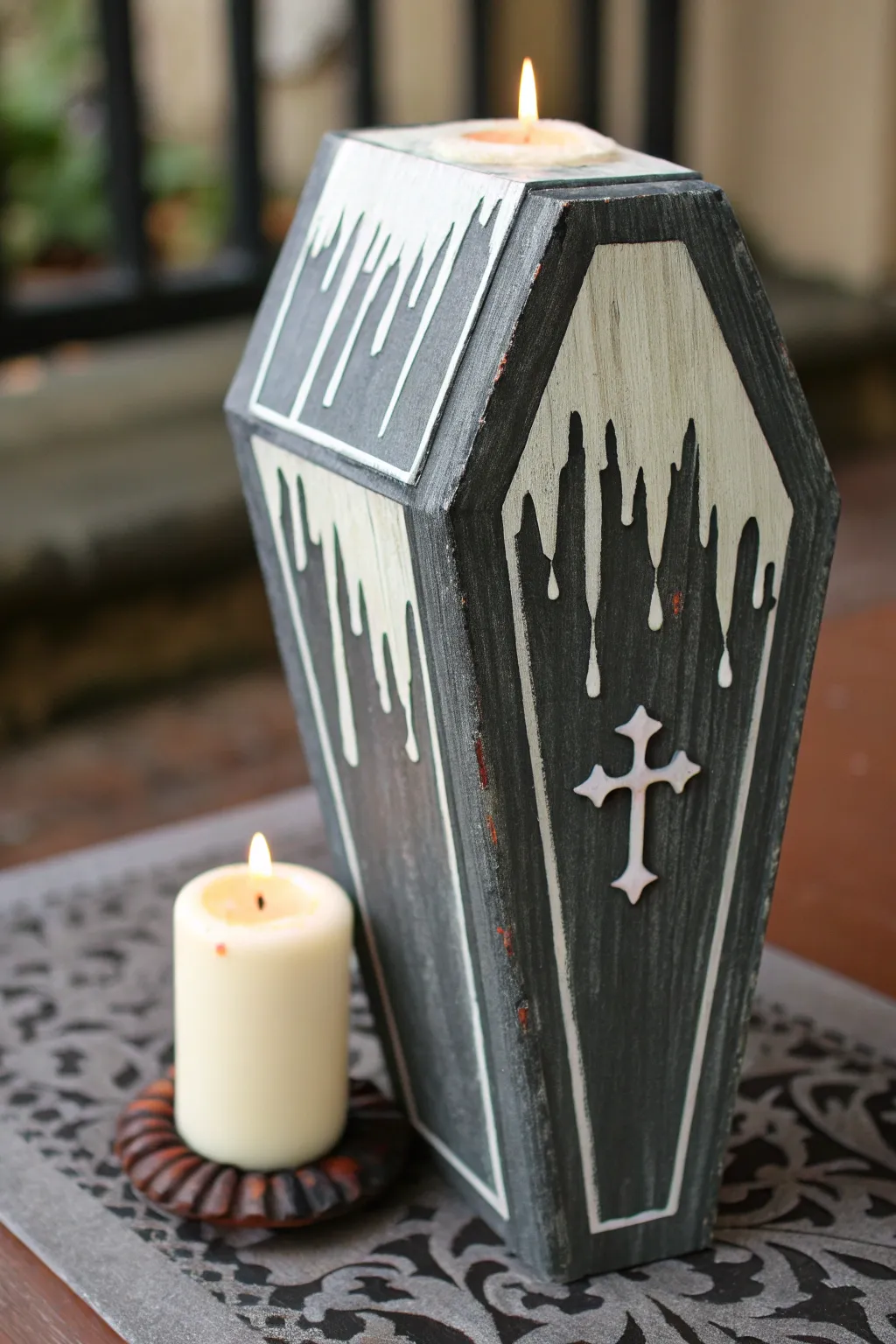 Coffin painted with creamy wax drips and tiny candle flames for a moody minimalist look