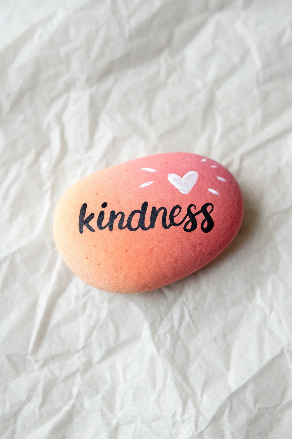 Paint a simple kindness rock in soft pastels with a tiny heart for an easy kids craft.
