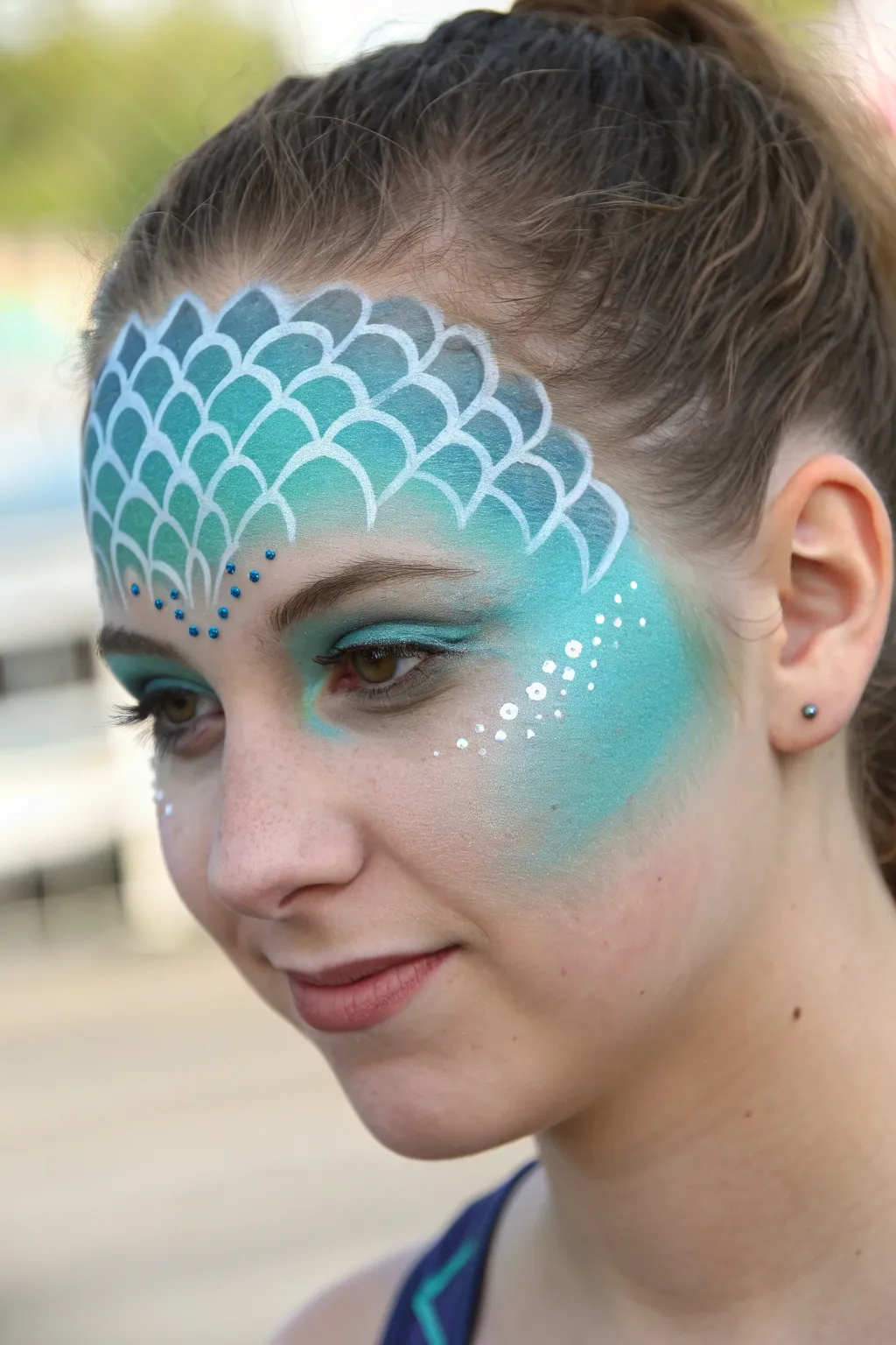 Mermaid scale gradient full-face paint in ocean blues with bright wet-look highlights