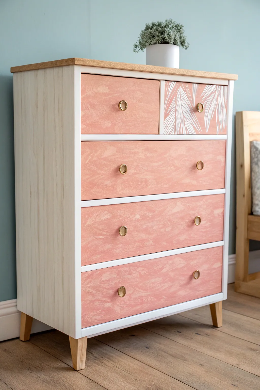 Neutral pastel dresser with one open drawer revealing a bold pop-color interior surprise