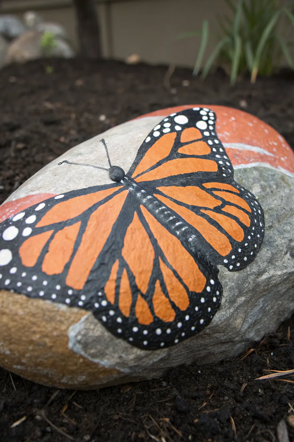 Oversized Monarch butterfly wings on a wide boulder, bright and bold against earthy soil.